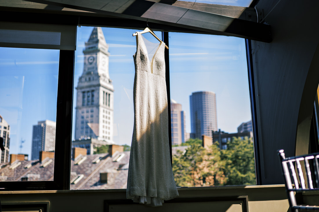 Bride's dress hanging with the Boston skyline behind it at the Bostonian Hotel