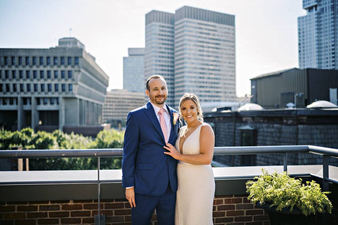 Bride and groom pose on Bostonian Hotel rooftop