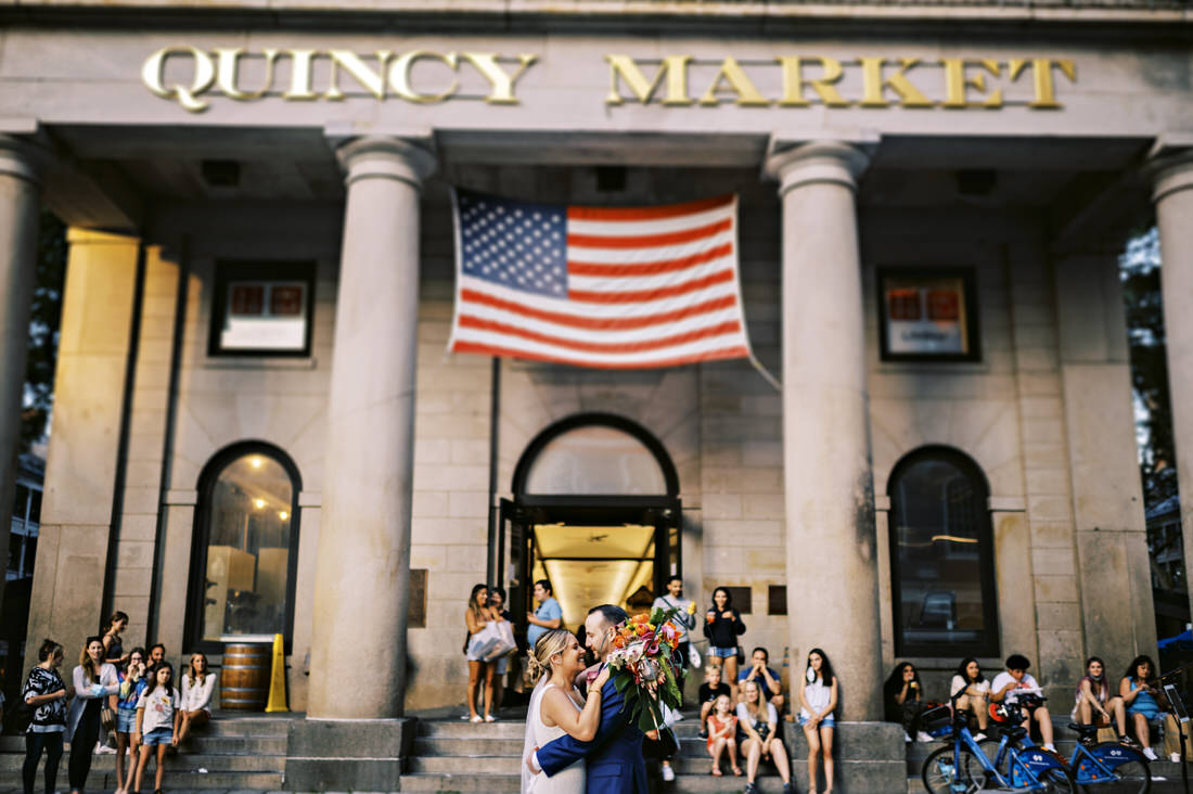 Bride and groom kissing in Quincy Market