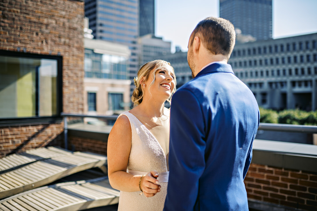 Bride and groom smiling at each other during their first-look at the Bostonian Hotel