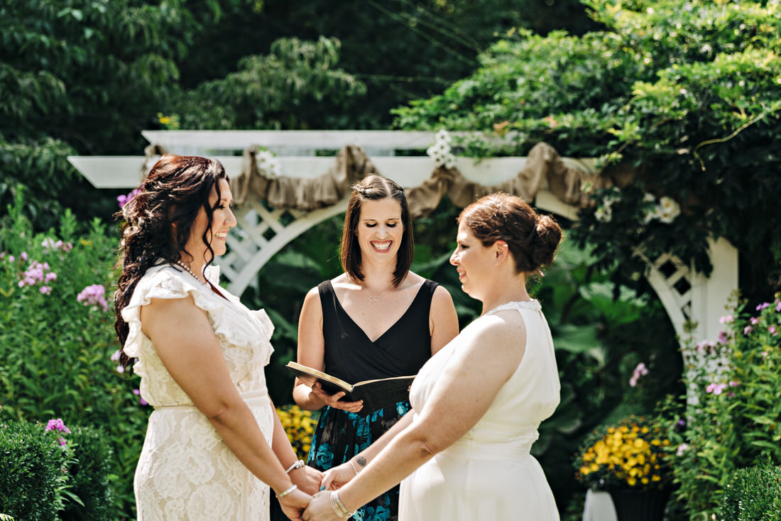 Brides holding hands at their wedding ceremony
