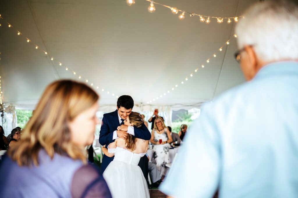 Bride and groom first dance during tented wedding reception at The House of Seven Gables