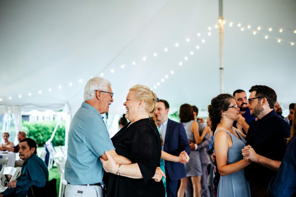 Candid photos during tented wedding reception at The House of Seven Gables