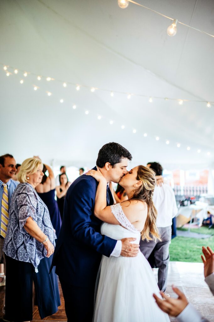 Candid photos during tented wedding reception at The House of Seven Gables