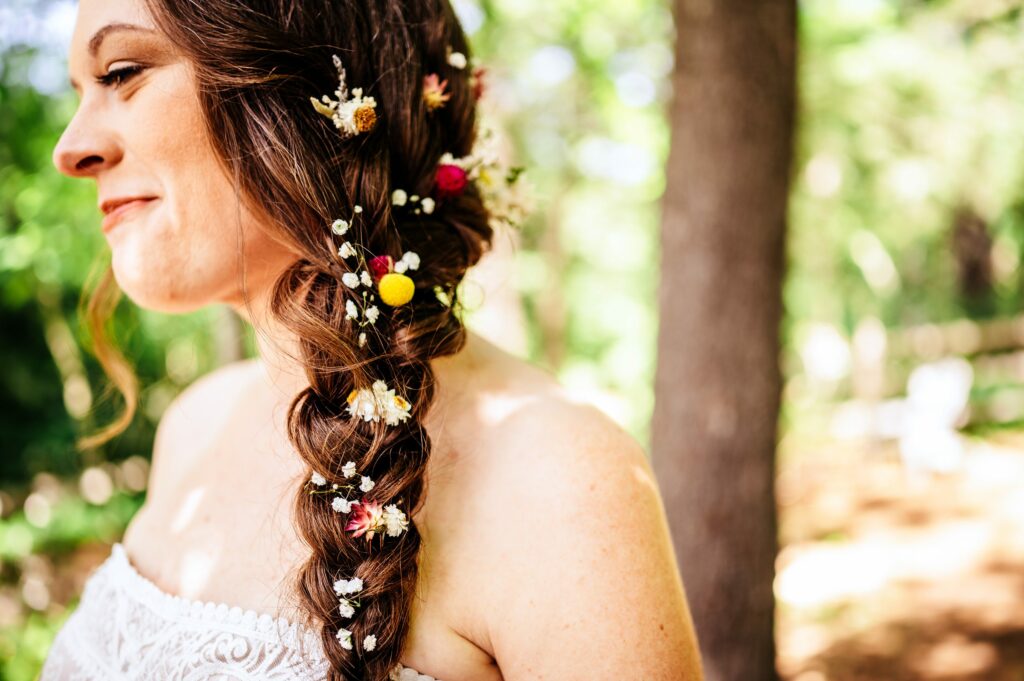 Bride with flowers in her braided hair for laid back wedding