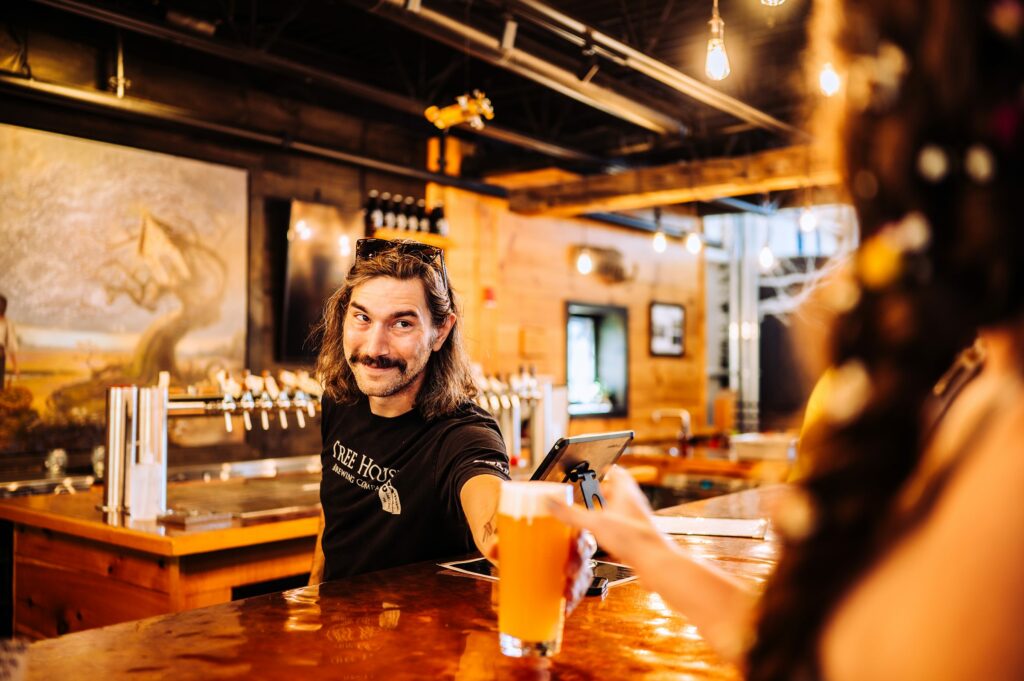 Man serving drinks to bride and groom 