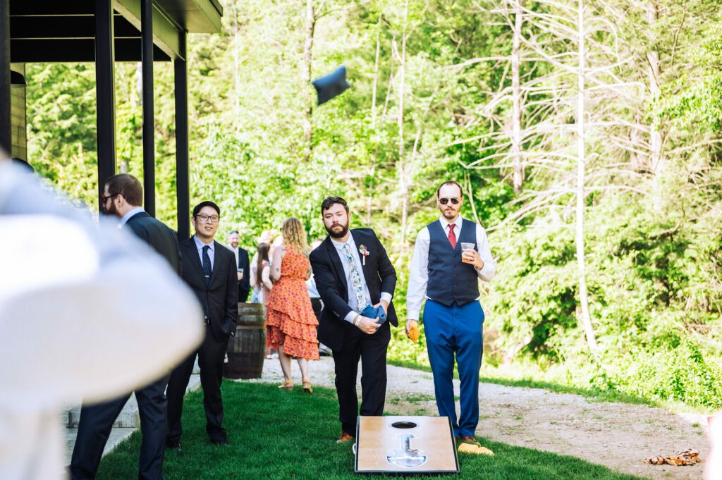 Guests playing cornhole at wedding