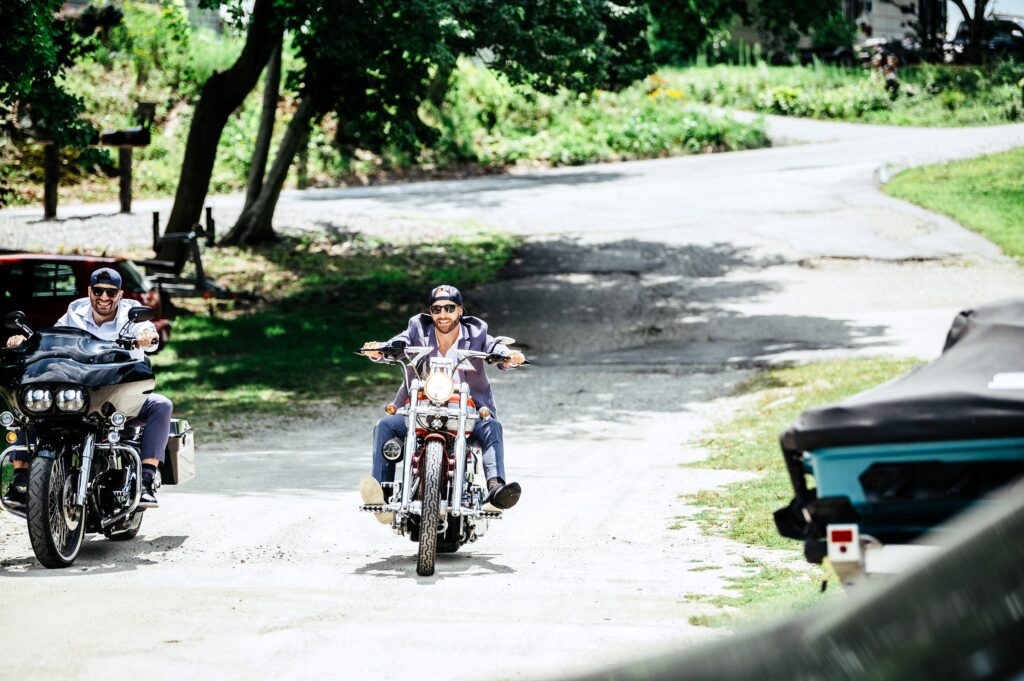 Groom riding into wedding on a motorcycle 