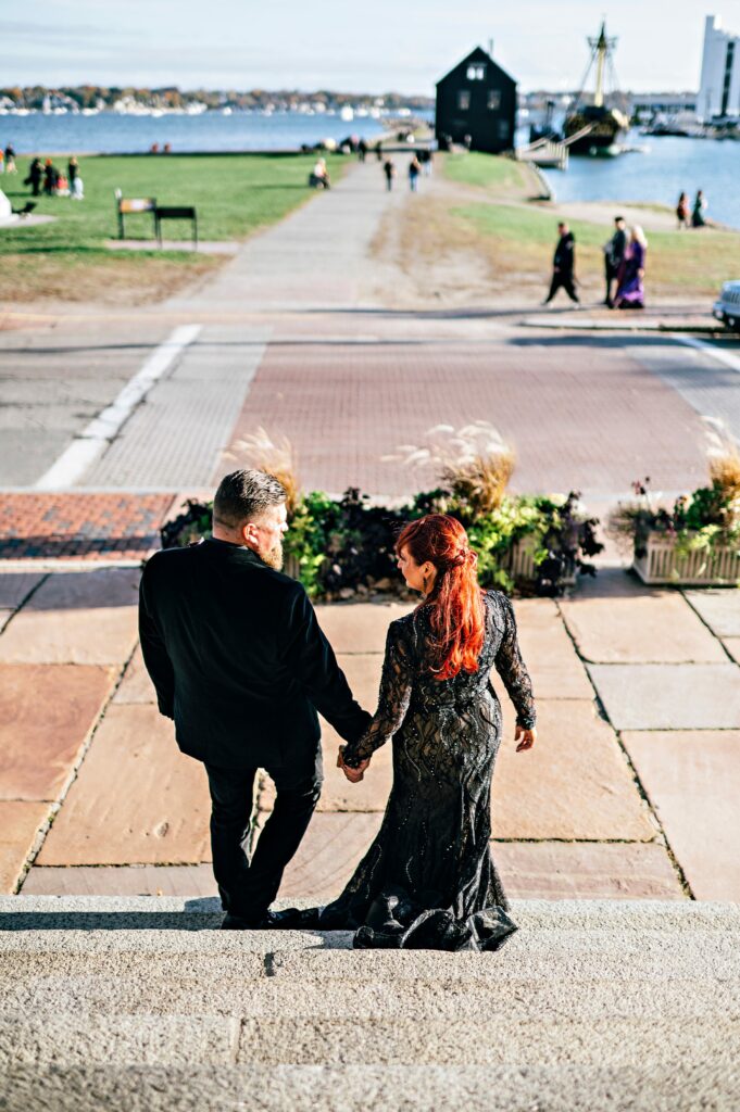 Bride and groom hand in hand overlooking the Salem waterfront 