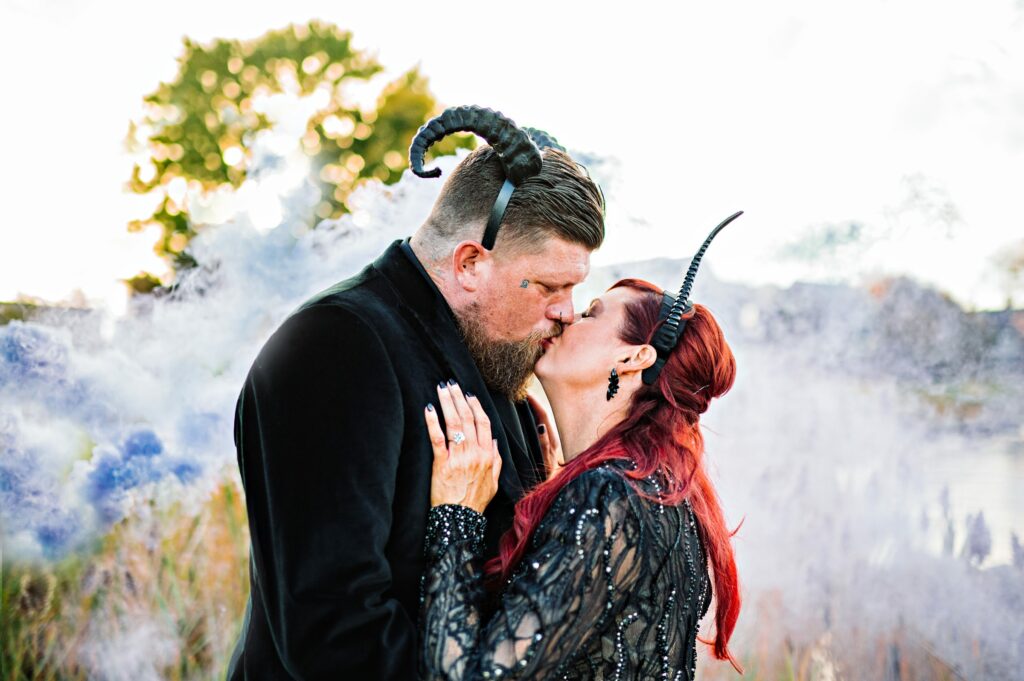 Portrait of bride and groom kissing using smoke bombs