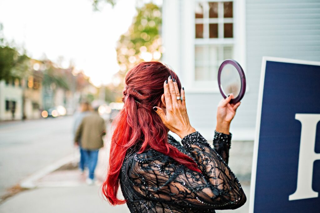 Candid photo of bride checking her hair in the street before ceremony 