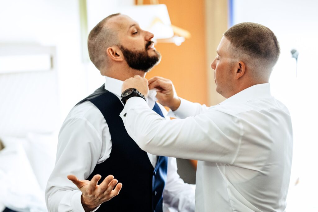 Groom putting on bowtie