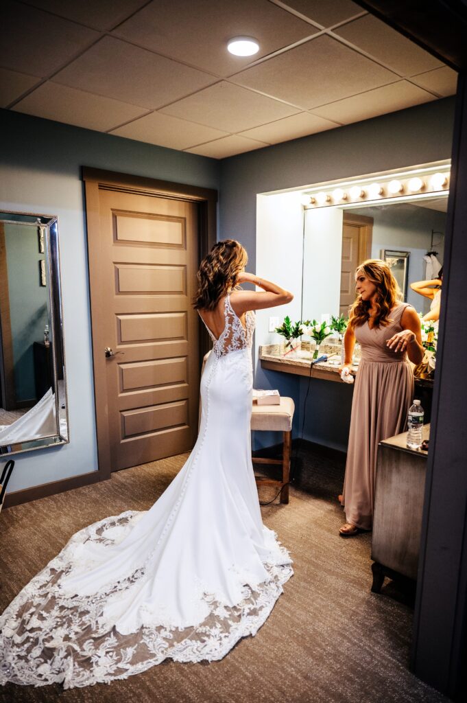 Bride putting on her gown in the bridal suite at The Barn at Wight Farm