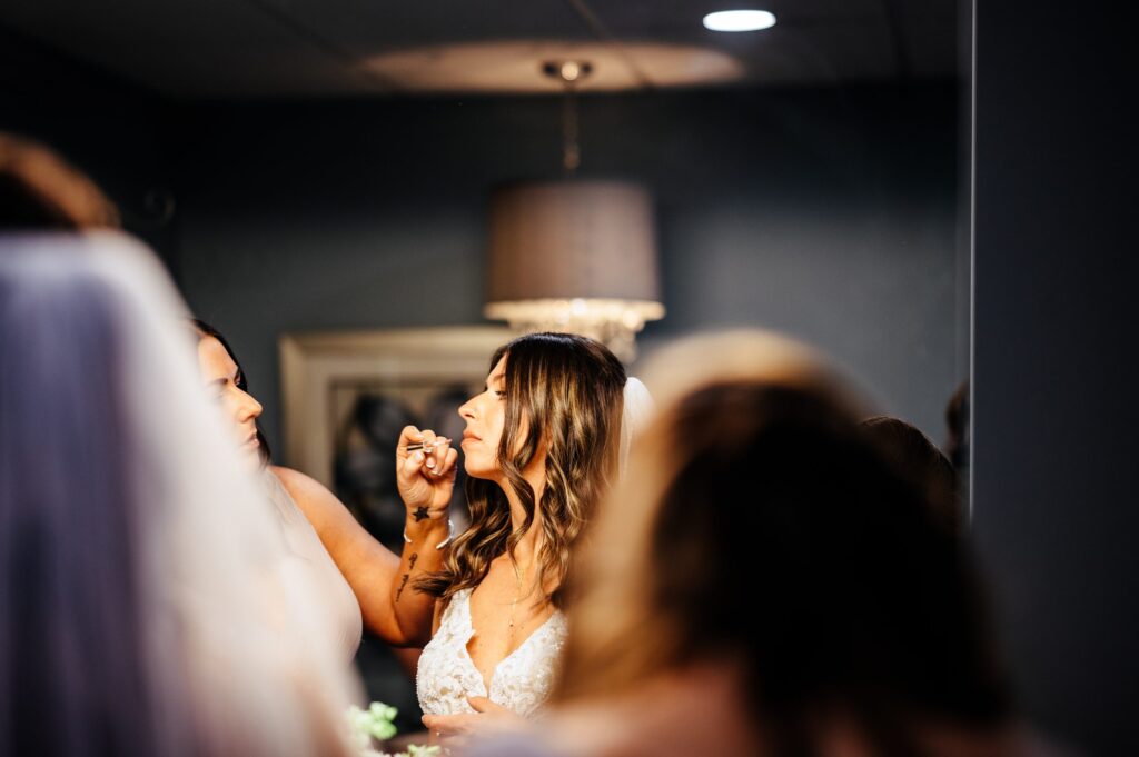 Bride getting lipstick put on getting ready portrait