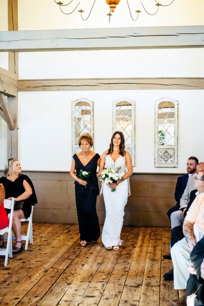 Bride walking down the aisle with her mother at The Barn at Wight Farm in the Alpheas Room