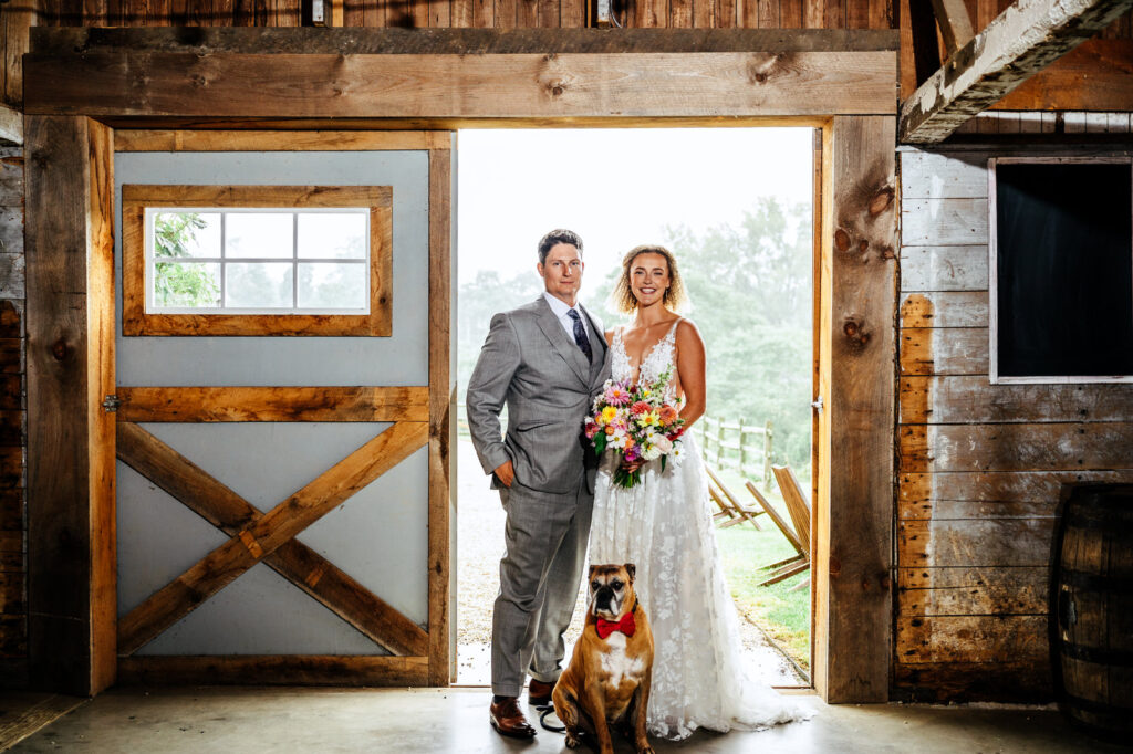 Bride, groom, and their dog posing for a portrait