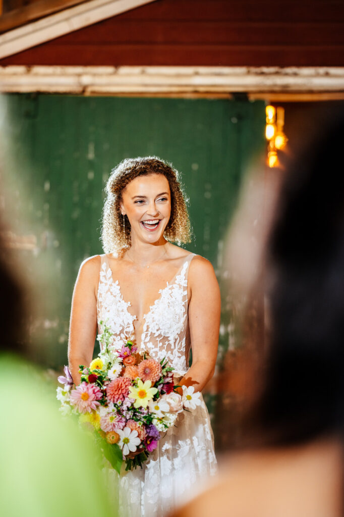 Bride smiling at her bridesmaids during a first look