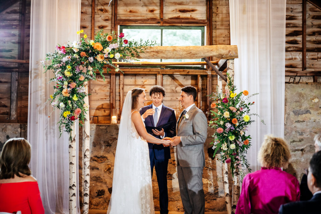 Bride and groom holding hands during their wedding ceremony at South Farms