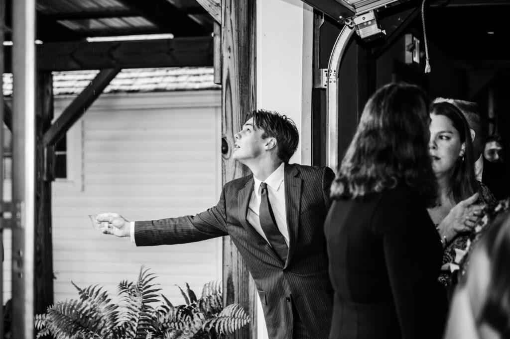 Young man holding out cup in the rain