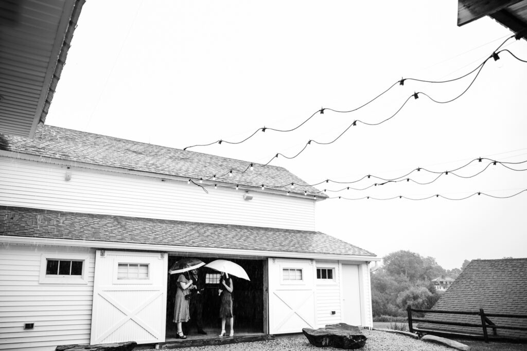 Two guests holding umbrellas during rainy cocktail hour