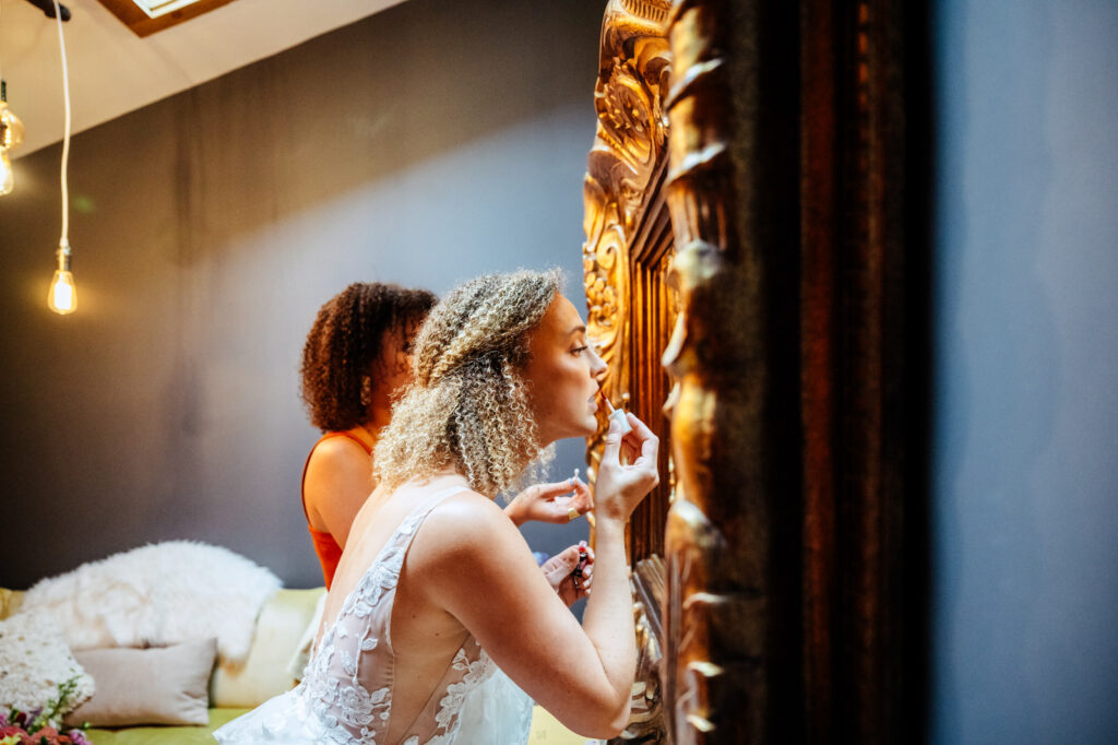 Bride putting lipstick on in mirror