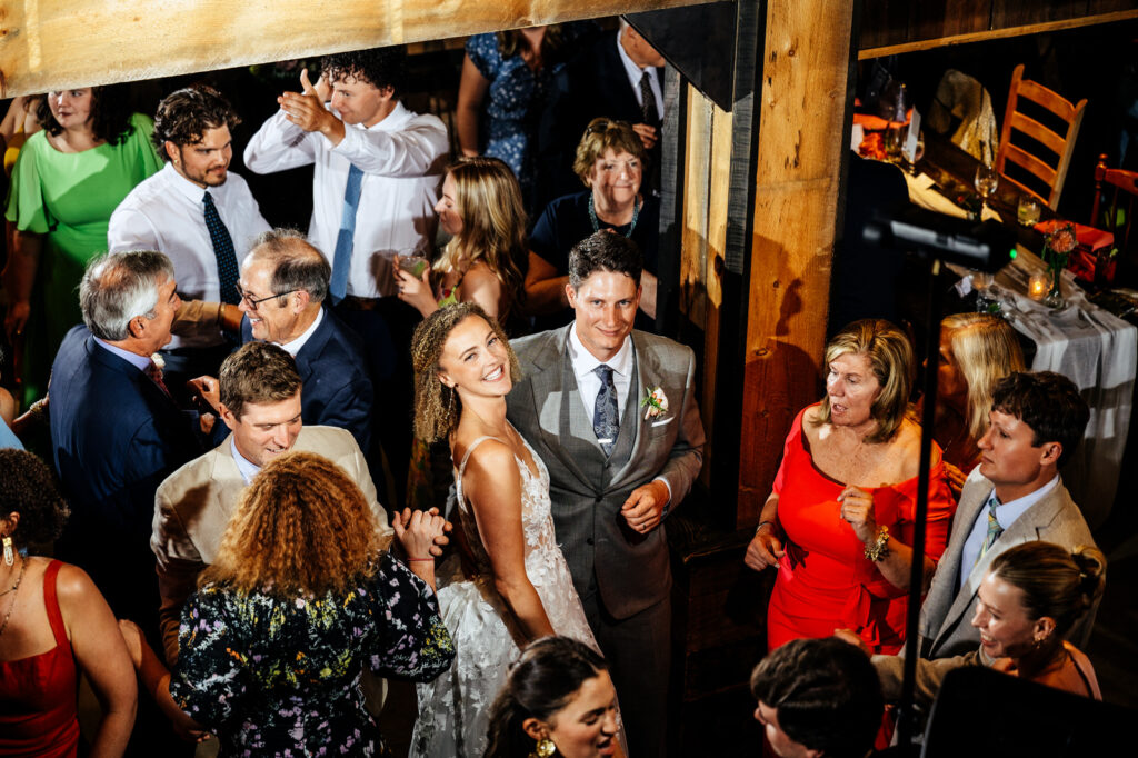 Smiling bride and groom in a crowd of guests