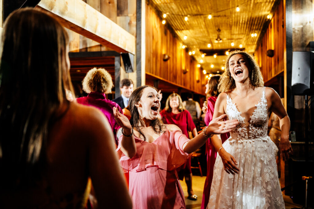 Bride and bridesmaid dancing during wedding reception