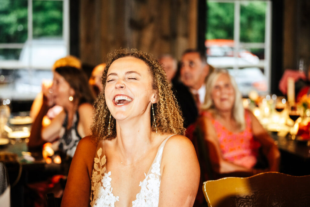 Bride throwing her head back laughing