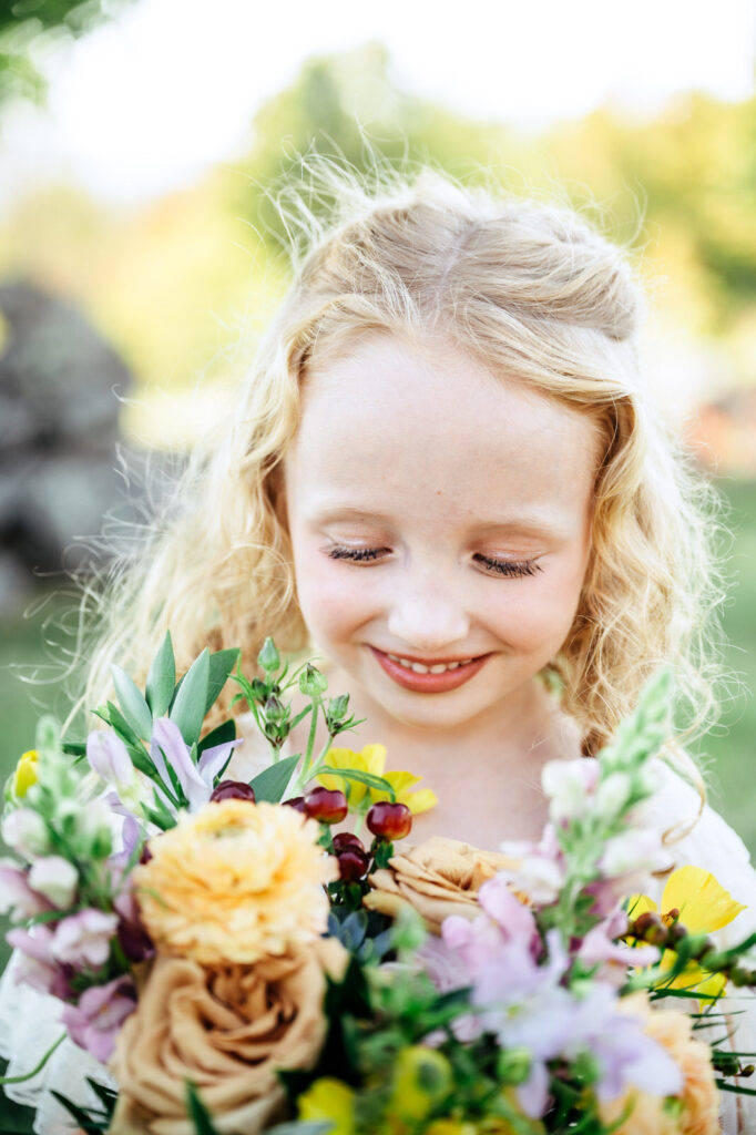 Bride's daughter smiling at flowers