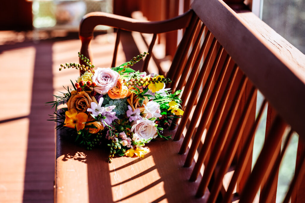 bridal bouquet laying on a red bench
