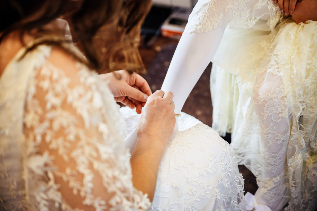 Bride helping her daughter get ready