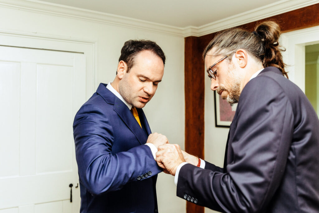 Groom's friend fixing his cufflinks
